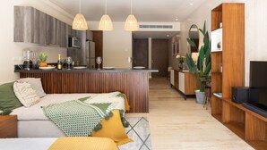 A modern kitchen with a central island, wooden cabinets, and pendant lighting. - Casa Luna 1BR by the Pool - Attha Cenote (Tulum)