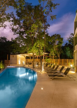 Alberca al aire libre y camastros 