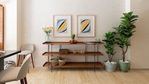 A modern dining area with a wooden table, chairs, a shelf with decorative items, and two framed artworks. - Casa Sol 1BR by the Pool - Attha Cenote (Tulum)