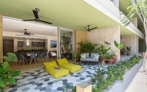 A modern outdoor living area with a hexagonal tiled floor, yellow seating, and various potted plants. - Casa del Agua 2 BR Jungle Views - Attha Cenote (Tulum)