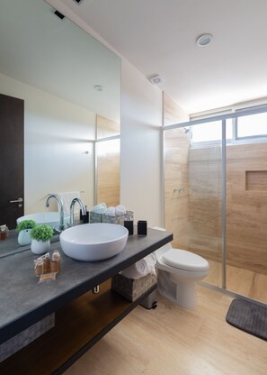 A modern bathroom with a large sink, mirror, and shower. - Villa Parota 1 BR at Attha Cenote (Tulum)