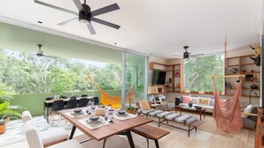 A spacious living area with a dining table, sofas, and hammocks. - Casa Marisol 2BR Tulum Spirit - Attha Cenote (Tulum)