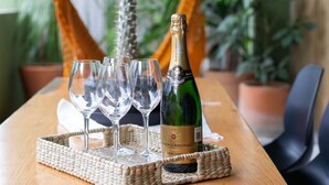 A table with a bottle of champagne, three glasses, and a woven coaster. - Casa Marisol 2BR Tulum Spirit - Attha Cenote (Tulum)