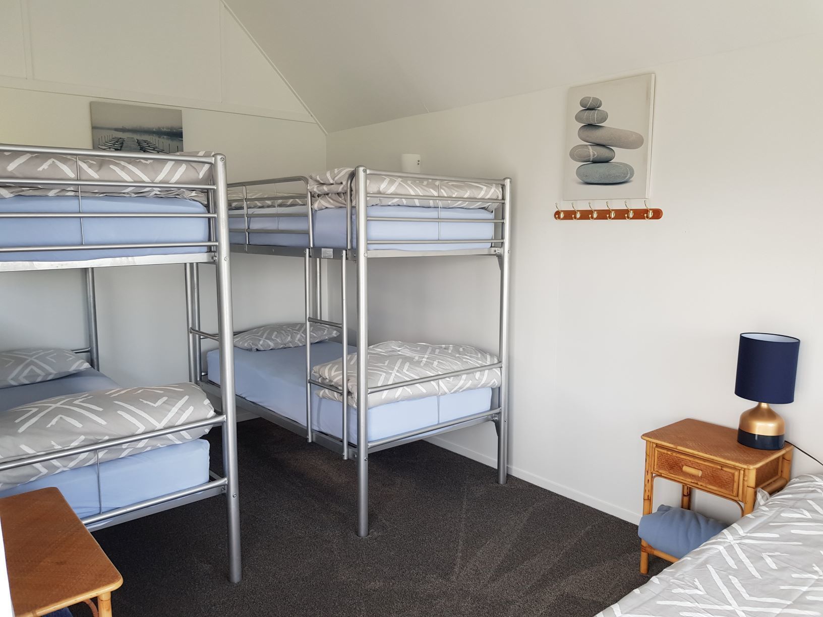A bunk bed room with a small wooden table and a lamp.