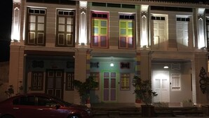 A two-story building with a car parked in front. - Secret Garden Homestay (George Town)