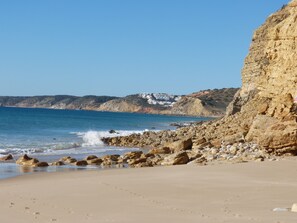 Une plage côtière au paysage rocheux, offrant une vue dégagée sur la mer.