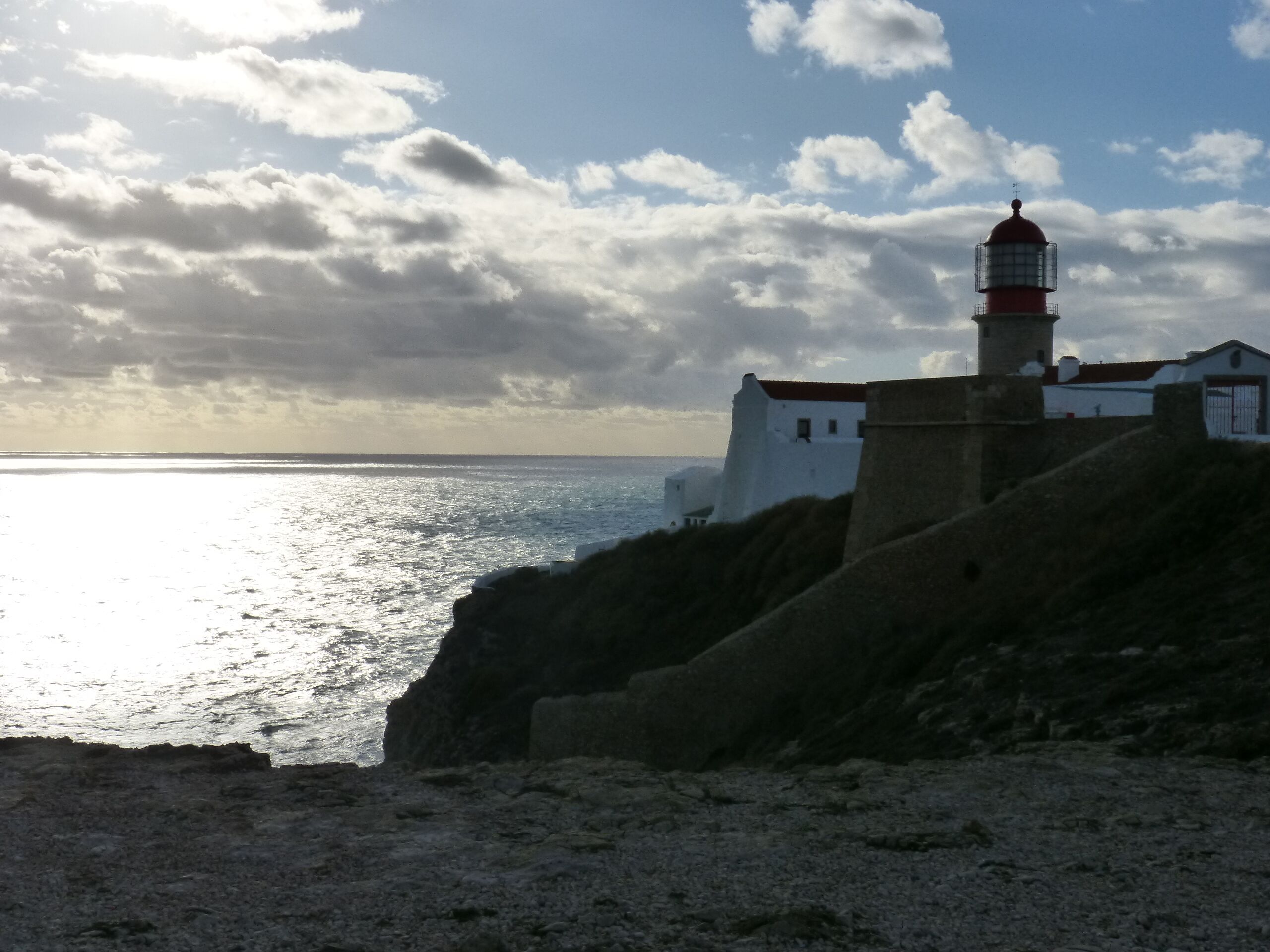 Vista costera con un faro y edificios blancos.