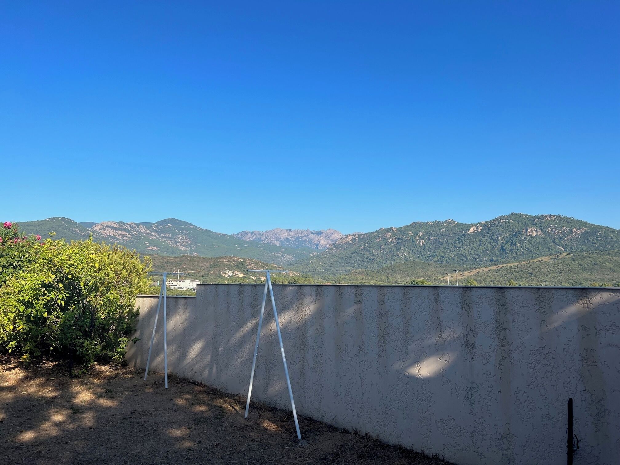 Blick auf eine gebirgige Landschaft mit blauem Himmel.
