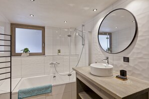 Een bad, een haardroger, handdoeken, toiletpapier