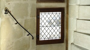 A stone wall with two windows, each with a wooden frame and metal bars. -  A privileged vacation out of time, Be the Châtelains of the Manor.     (Birac-sur-Trec)