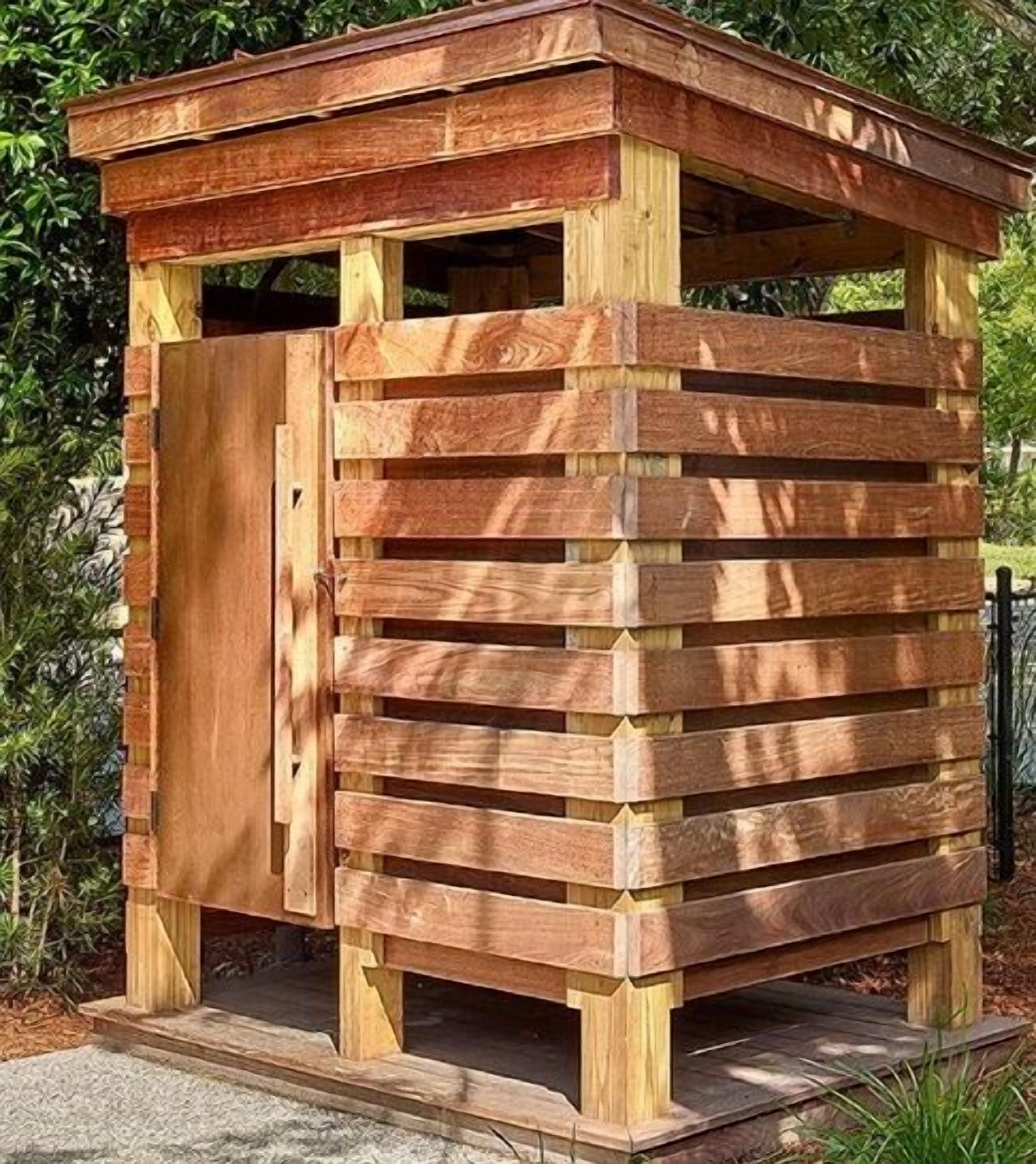 A wooden structure with a slatted design, possibly a gazebo or a small shelter.