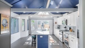Una cocina moderna con armarios blancos, electrodomésticos de acero inoxidable y una pared de acento azul.