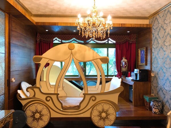 A cozy room with a wooden boat bed, a chandelier, and a window with curtains.