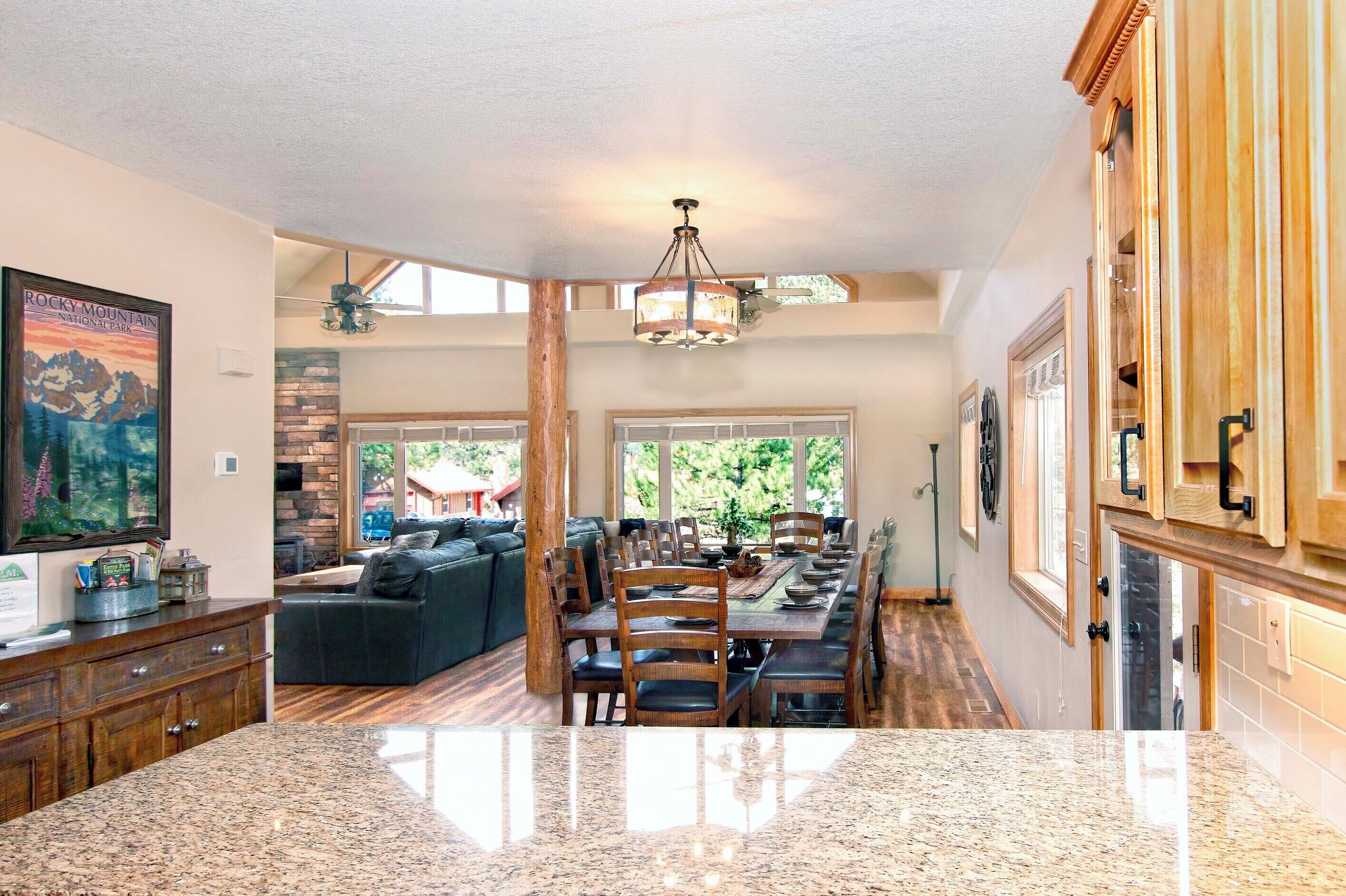 A spacious kitchen with granite countertops, wooden cabinets, and a dining area with a large table and chairs.
