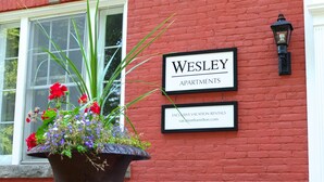 Schild für ‚WESLEY APARTMENTS‘ mit einer URL für Ferienwohnungen.