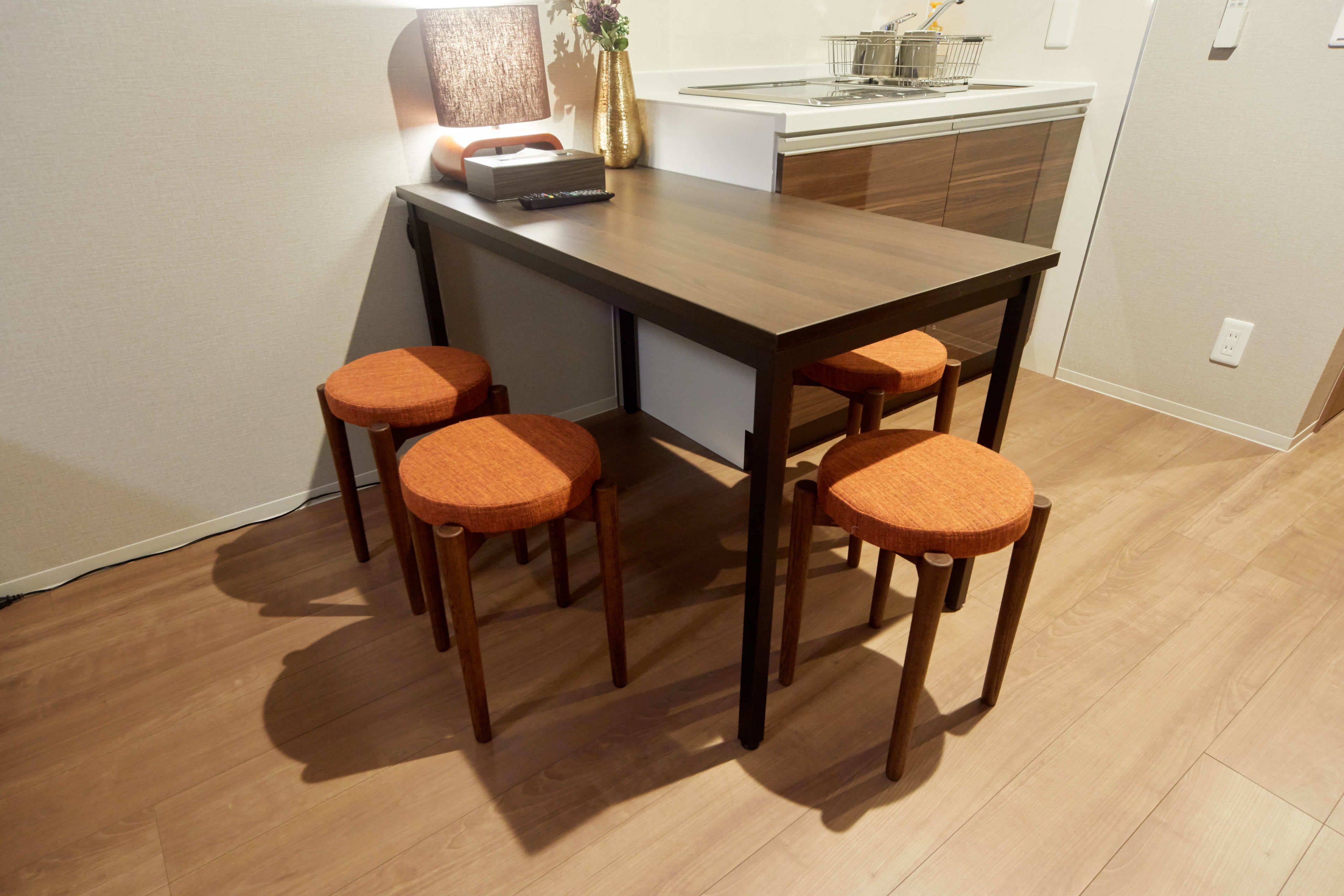 Een kleine keuken met een houten eettafel en vier bijpassende stoelen.