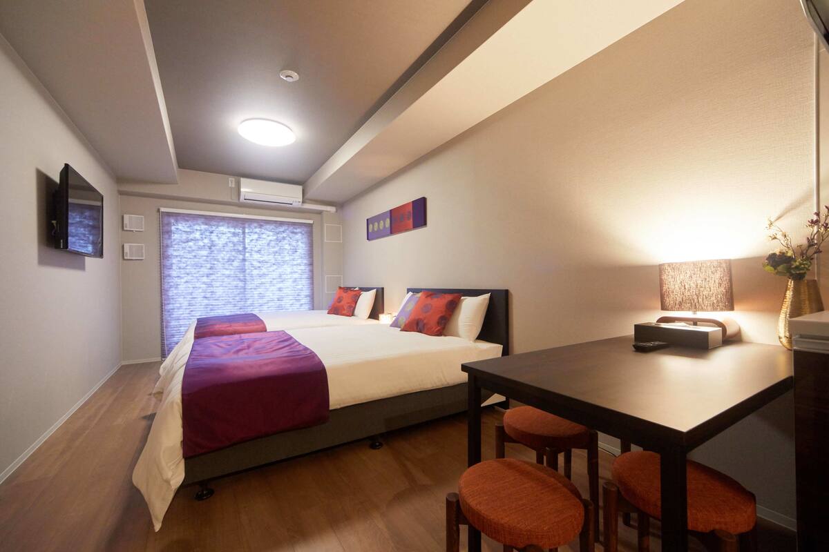 A bedroom with a bed, a desk, and a chair.