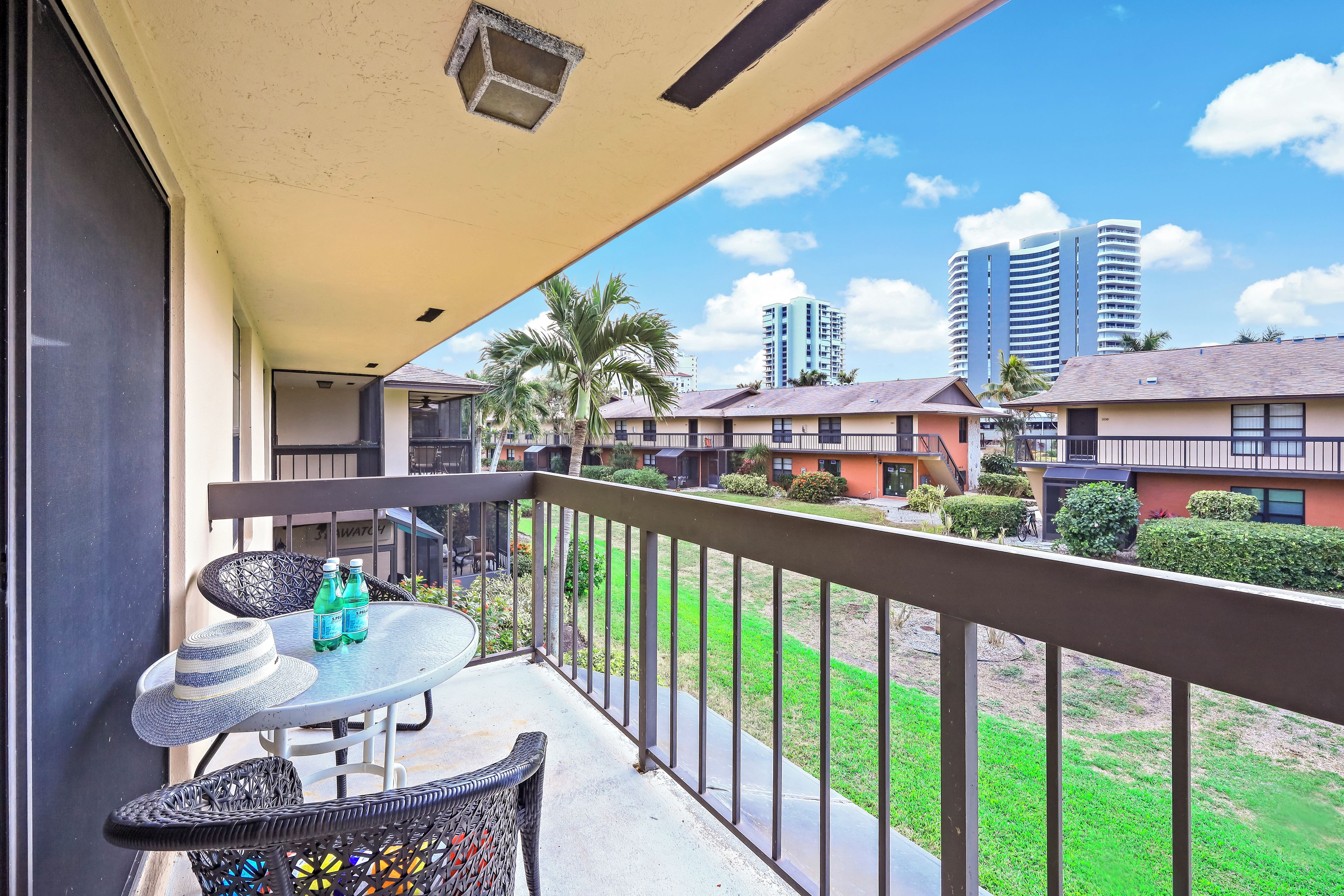 A balcony with a table, two chairs, and two bottles of water.