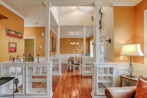 Experience a warm and inviting atmosphere in this elegantly designed space, featuring a polished floor, a central dining area, and tasteful artwork.