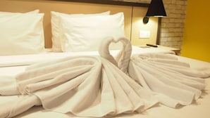 A neatly made bed with white towels arranged in a heart shape. - Nite & Day Laguna Bintan - Tanjungpinang (Tanjung Pinang)