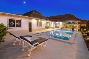 A swimming pool area with lounge chairs and a covered seating area. - Villa Bos Near the Beach of Jomtien (Pattaya)