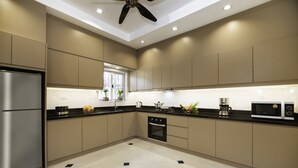 Uma cozinha moderna com geladeira de aço inoxidável, forno embutido e micro-ondas.