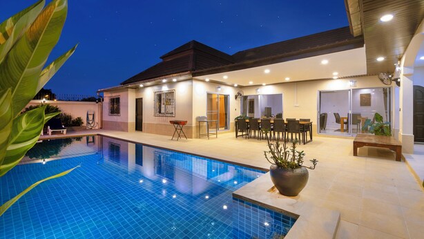 Um hotel moderno com piscina, área de estar ao ar livre e um alpendre coberto.