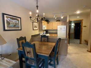 Enjoy meals in this kitchen with a central island, dining table, and chairs, plus a microwave and refrigerator.