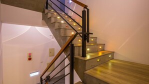 A modern staircase with wooden handrails and illuminated steps. - A walk in the mist (Lugu)