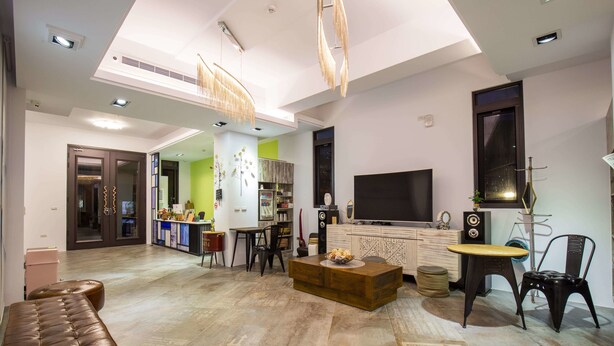 A modern living room with a sofa, coffee table, and TV. There is a kitchen area in the background with a dining table and chairs. - A walk in the mist (Lugu)