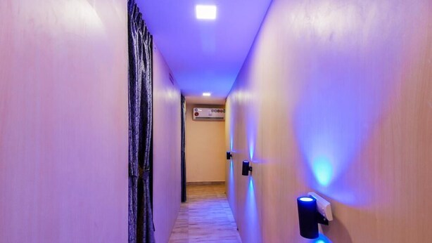 Un pasillo estrecho con suelo de madera, paredes pintadas en un tono claro e iluminación empotrada en el techo.