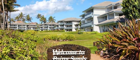 A hotel entrance with a sign reading "Welcome to Poipu Sands".