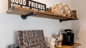Eine Küchenarbeitsplatte mit Kaffeemaschine, Tasse und einem Schild, auf dem 'HOME SWEET HOME' steht.