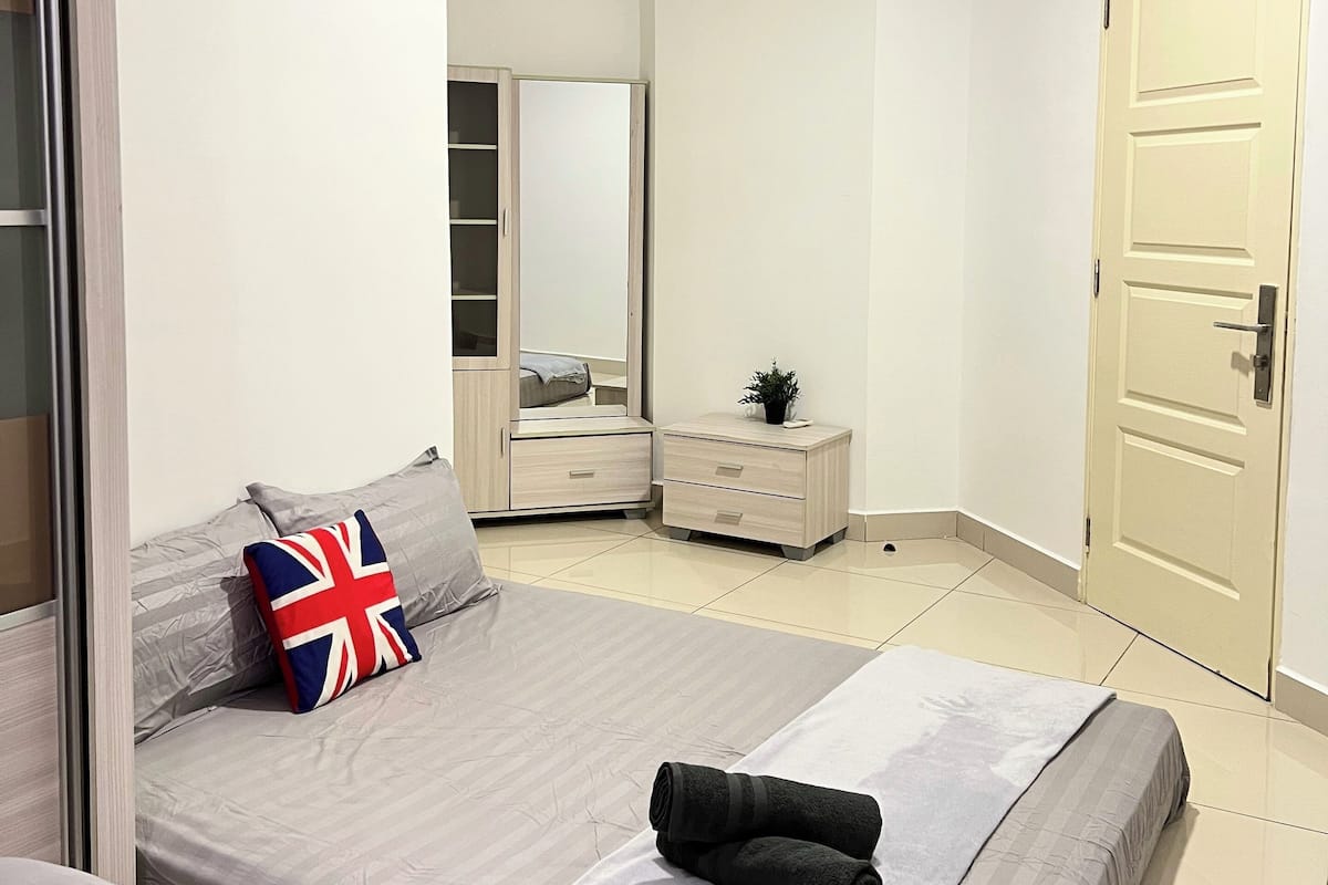 Ein Schlafzimmer mit zwei Betten, einem Kleiderschrank, einem Spiegel und einer Tür.