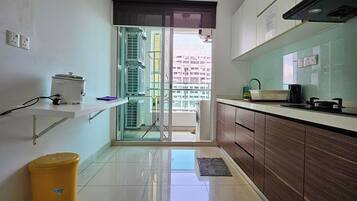 A modern kitchen with a large window, a sink, a stove, and a trash bin.