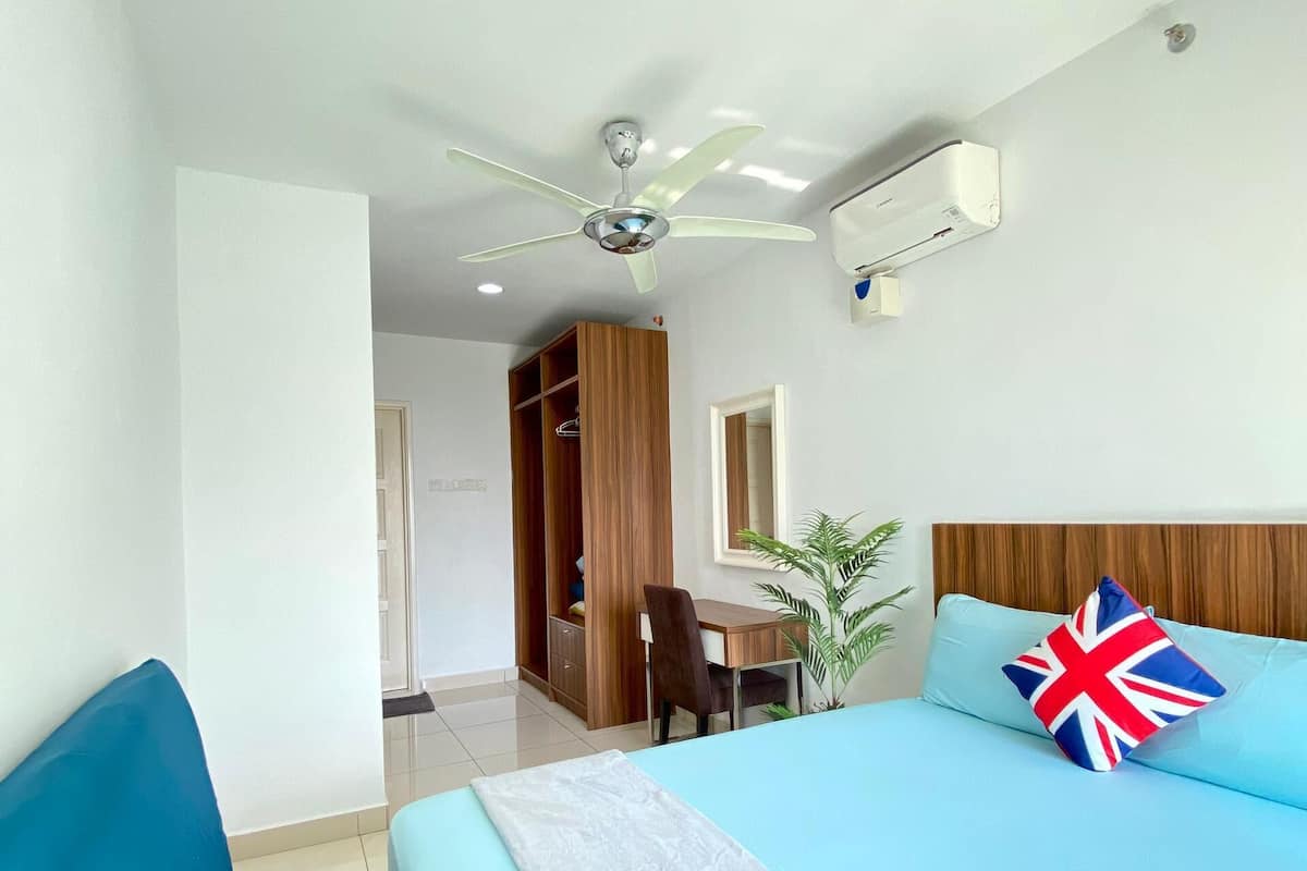 Ein Schlafzimmer mit Bett, Schreibtisch und Kleiderschrank.