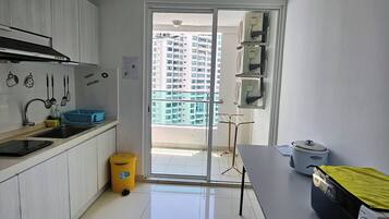 A modern kitchen with a sink, stove, and a window overlooking a residential area.