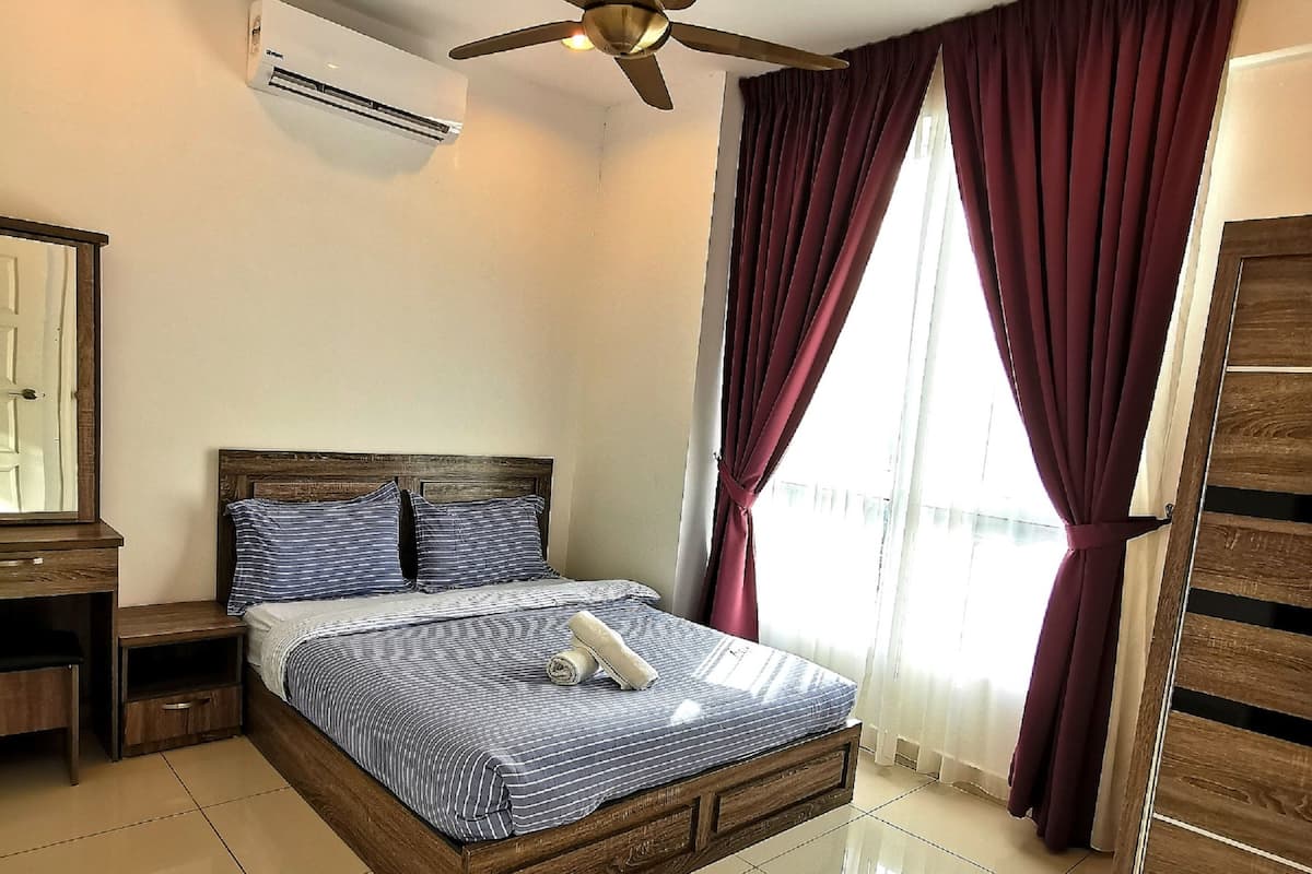 Ein Schlafzimmer mit Bett, Deckenventilator, Klimaanlage, Nachttisch und Kleiderschrank.