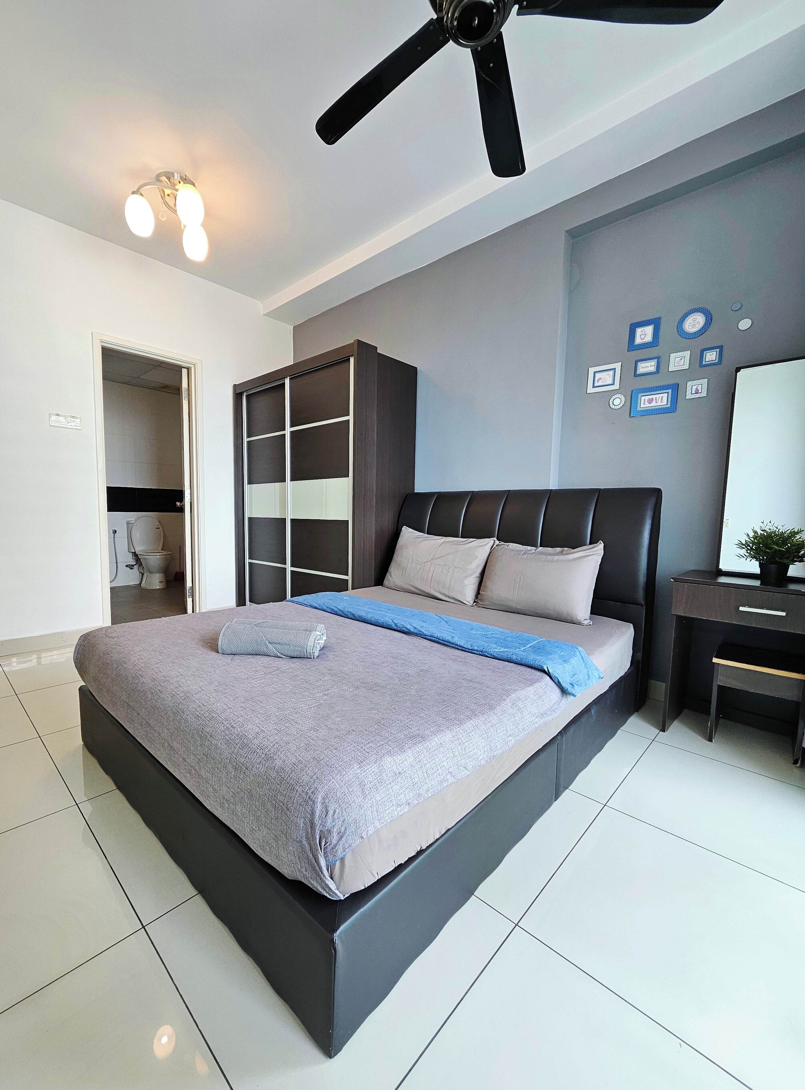Una camera da letto moderna con un letto, una ventola a soffitto, un armadio e una scrivania con una pianta.