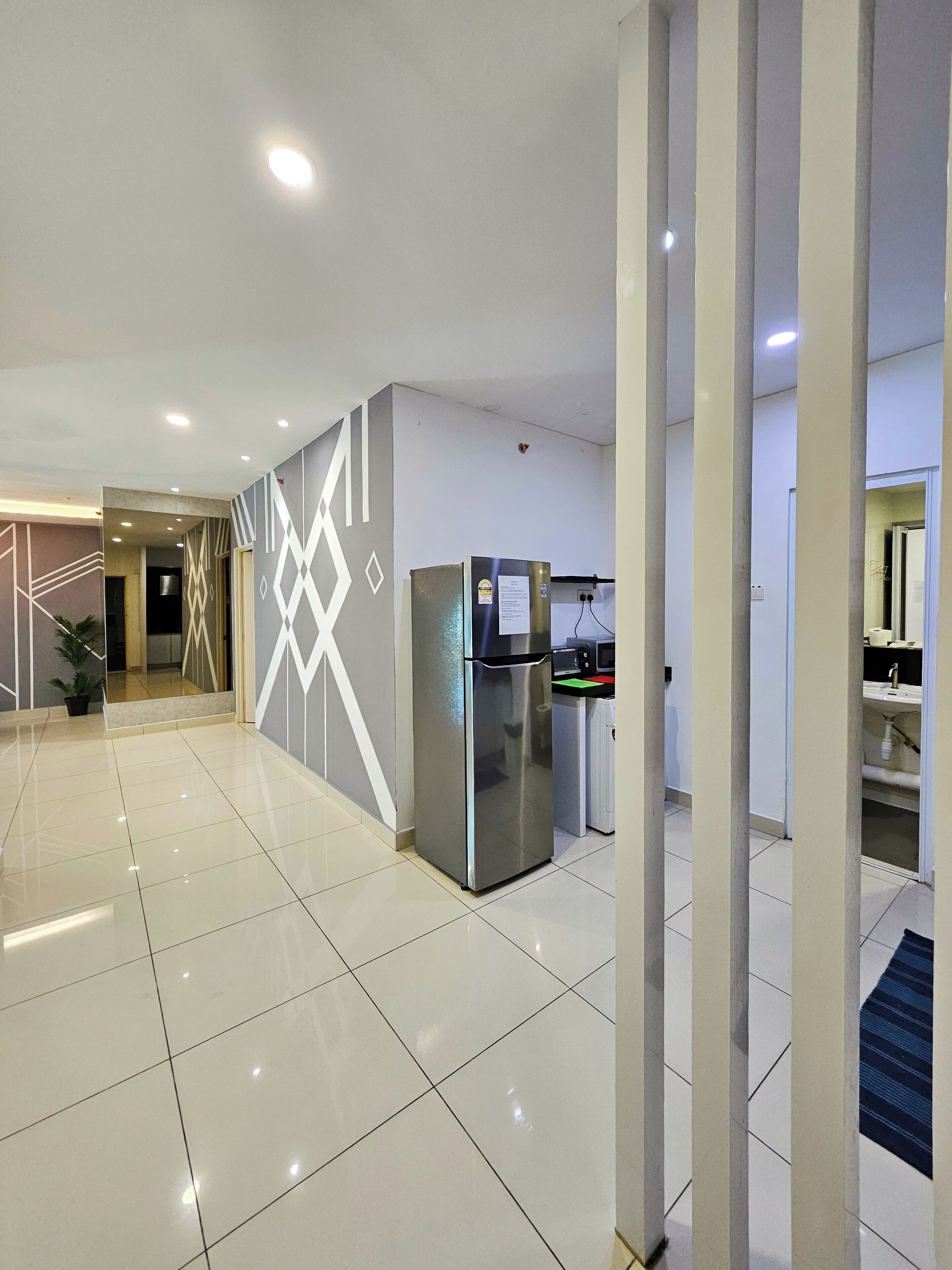 A modern hotel lobby with a shiny tiled floor, a refrigerator, and a microwave.