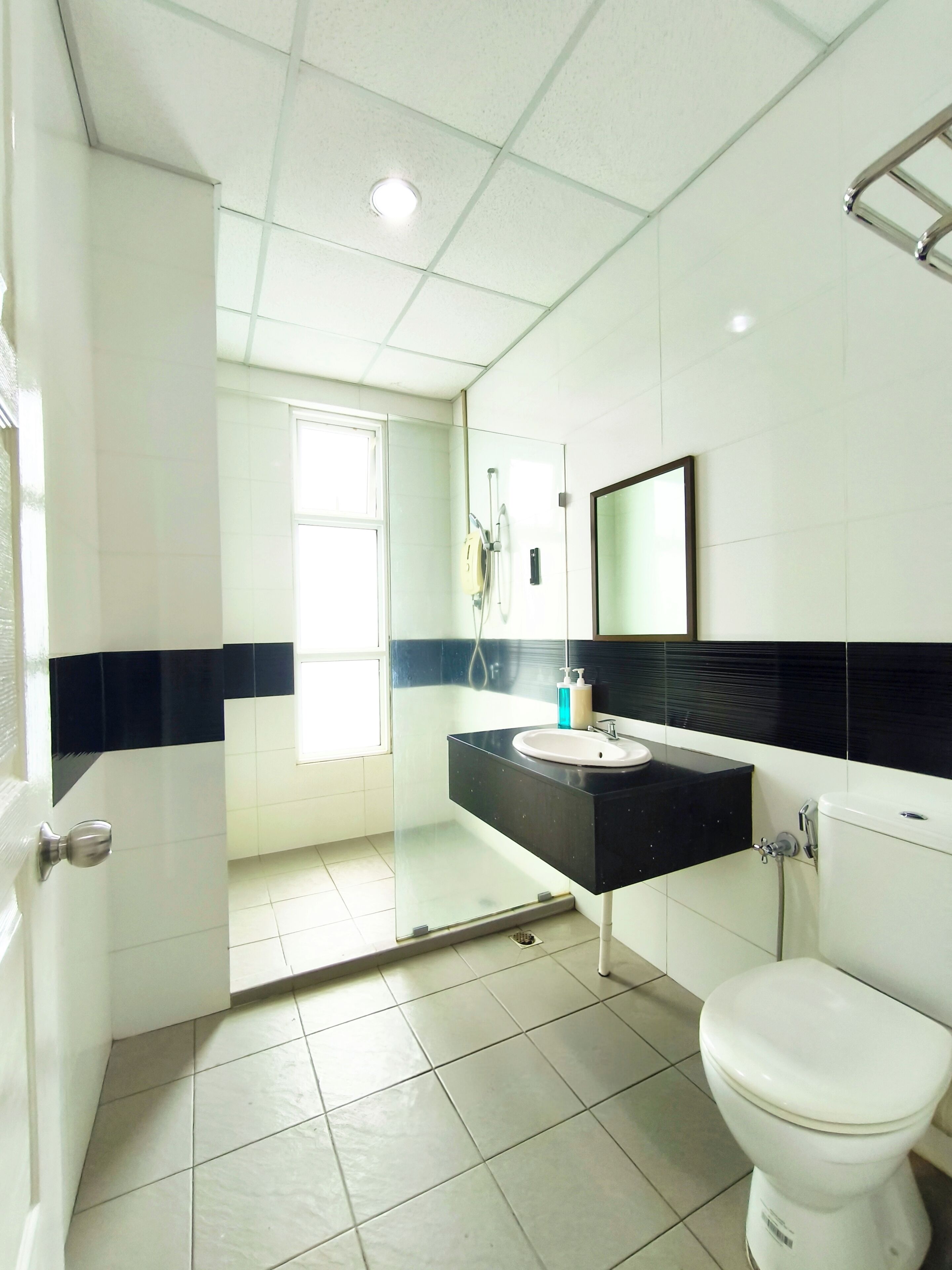 A bathroom with a toilet, sink, and shower.