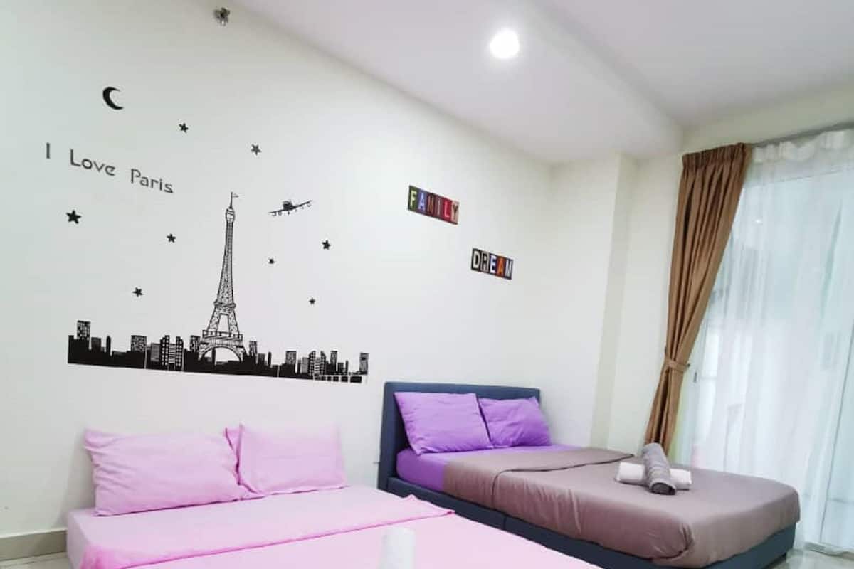 Ein Hotelzimmer mit zwei Betten, Stadtbild-Wandkunst und einem Schild mit der Aufschrift 'I Love Paris'.
