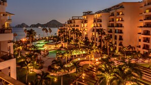 A resort with multiple buildings, a swimming pool, and palm trees.