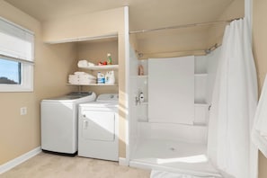 Bathtub, hair dryer, towels, shampoo