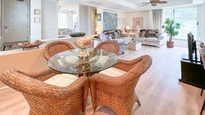 A spacious living area with a glass-top dining table surrounded by wicker chairs, a sofa set, and a large window offering a view of the outdoors. -  Beautiful, Palms At Wailea Condo #608- 2BR/2BA,GREAT LOCATION! SPECIAL Rates (Wailea)