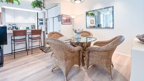 A modern kitchen with white cabinets, a dining area with wicker chairs, and a glass-top table. -  Beautiful, Palms At Wailea Condo #608- 2BR/2BA,GREAT LOCATION! SPECIAL Rates (Wailea)