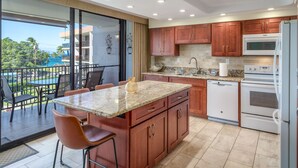 Eine moderne Küche mit Granit Arbeitsplatten, Holzschränken und Edelstahlgeräten.