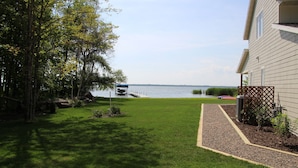 A house with a well-maintained lawn, a dock, and a view of a lake. - North Pine Cottage #1 (Brainerd)