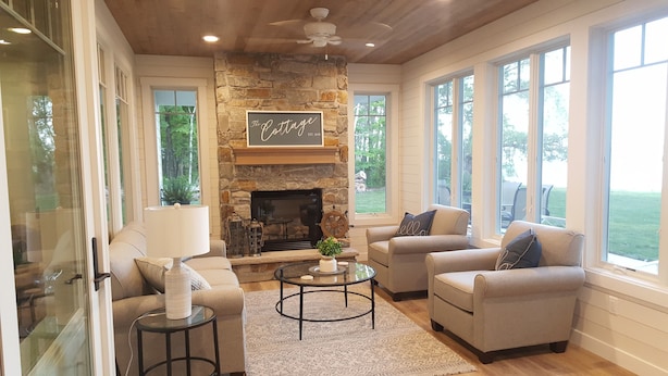 A cozy living room with a stone fireplace, two sofas, and a coffee table. - North Pine Cottage #1 (Brainerd)