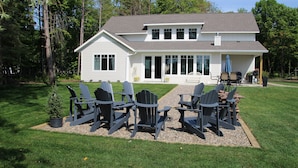 A two-story house with a covered patio area. - North Pine Cottage #1 (Brainerd)